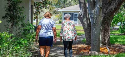 Two women walking together along a garden path