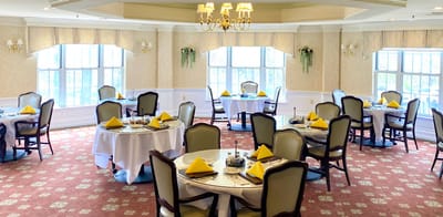Dining room setup with tables and yellow napkins