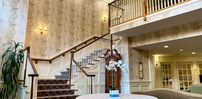Interior view of a lobby with a staircase and seating area
