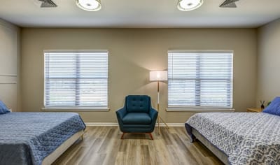 Spacious resident room with two beds and a seating area