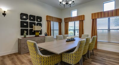 Bright dining area with large table and decorative windows