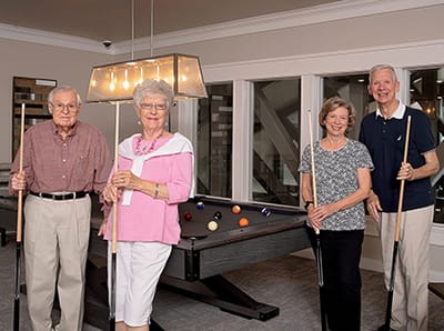 Residents playing pool in a lounge area