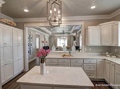 Bright kitchen interior with white cabinets and flowers
