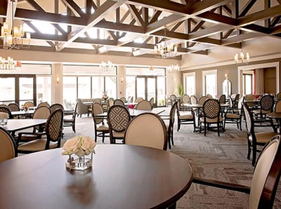 Bright dining room with set tables and flowers