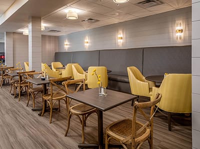 Bright dining area with yellow chairs and tables