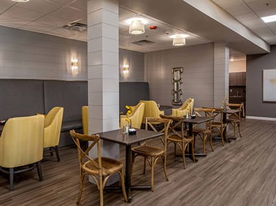 Cozy dining area with yellow chairs and wooden tables