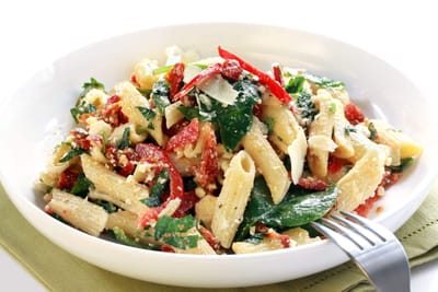 A plate of pasta salad with vegetables