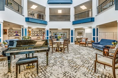 Bright common area with seating and a piano