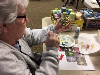 Resident painting an ornament during an activity