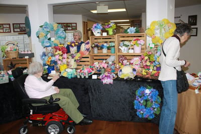 Residents participating in a craft activity surrounded by flowers