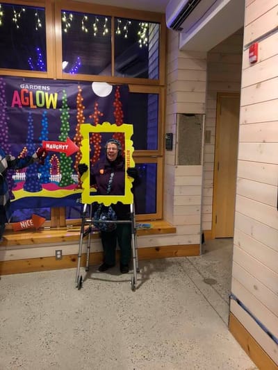 Resident posing with a frame at an event in a common area