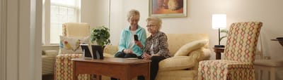 Caregiver assisting a resident in a cozy living area