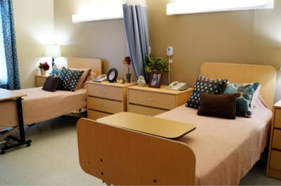 A shared resident room with two beds and personal items