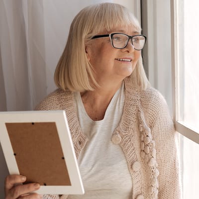 A smiling senior woman looking out the window