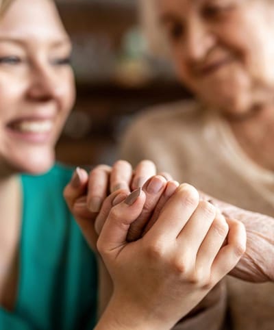 Caregiver holding hands with a senior resident