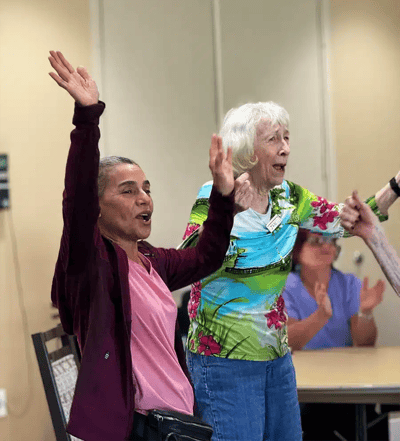 Residents enjoying a lively activity with raised hands
