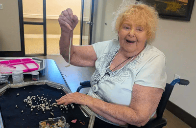 Resident engaged in a craft activity with beads