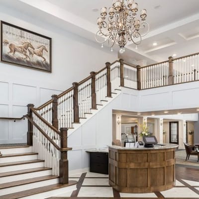 Bright, welcoming lobby with elegant staircase and chandelier