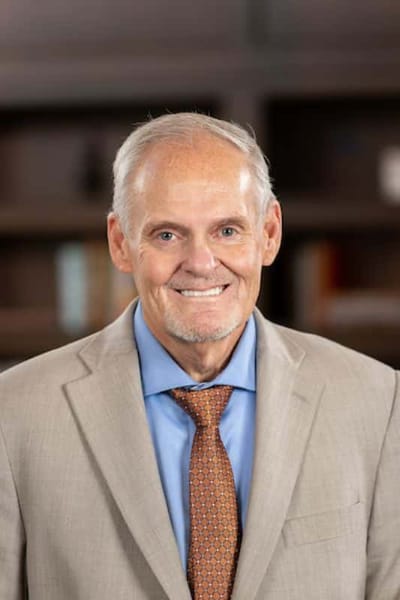 Smiling resident in a suit with a well-lit background
