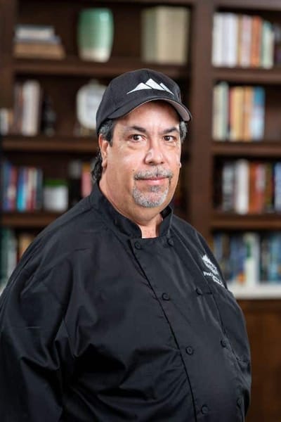 Chef posing in a well-lit kitchen area