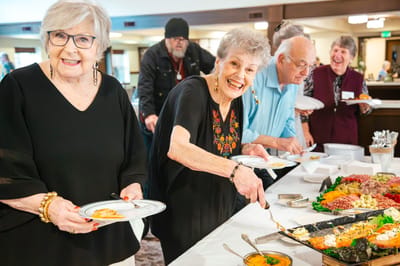Residents serving themselves from a buffet during an event