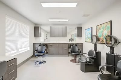 Hair salon area with styling chairs and mirrors