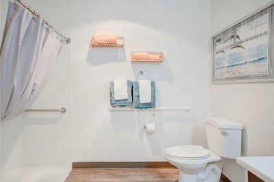 Well-lit bathroom with modern amenities and towels