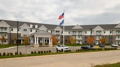 Exterior view of a senior living facility with flag