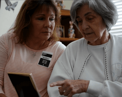 Caregiver and resident looking at a photo together