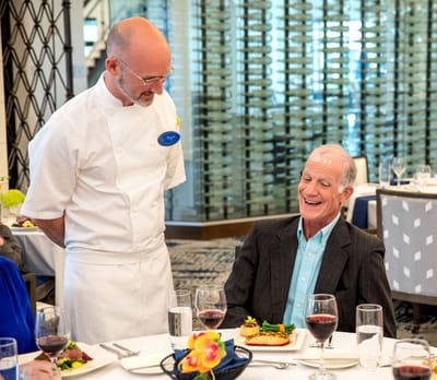 Resident enjoying a meal with staff in the dining room