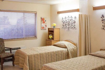 A cozy resident room with two beds and decor