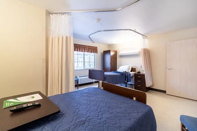 A private resident room with a bed and window