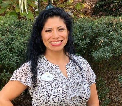 Staff member smiling in a garden area