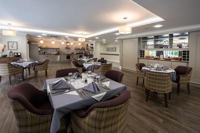 Dining area with elegantly set tables and a modern kitchen