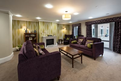 Common area with purple sofas and decorative wall