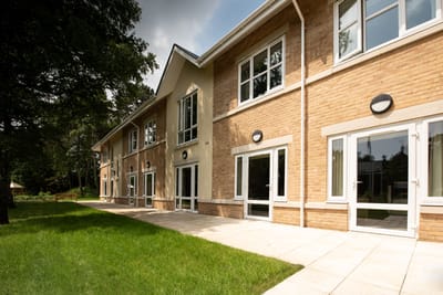 Exterior view of a senior living facility with grass