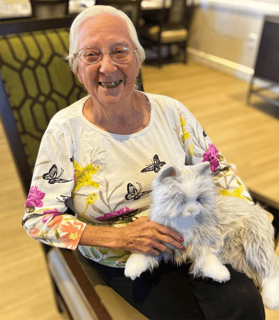 Resident smiling while holding a plush cat
