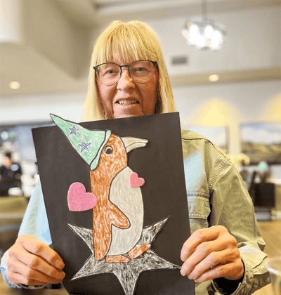 Resident proudly displaying artwork in a common area