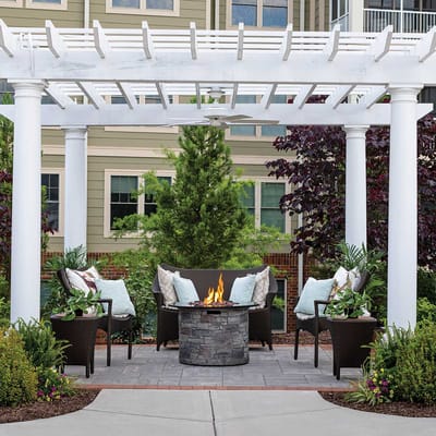 Outdoor seating area with fire pit and greenery