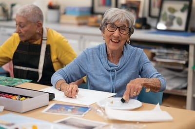 Residents engaging in an art activity at a table