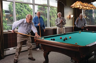 Residents playing billiards in a social room