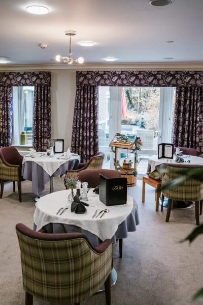 Dining area with elegantly set tables and curtains