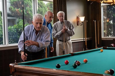 Residents playing billiards in a common area