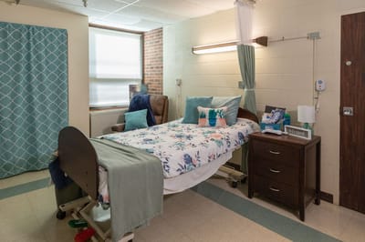 Private resident room with a floral bedspread and seating area