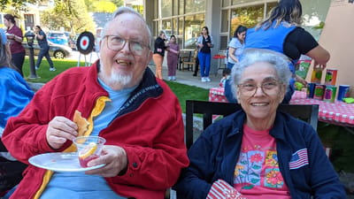 Two residents enjoying snacks in an outdoor setting