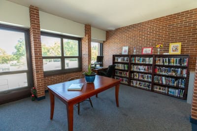 A cozy library area with bookshelves and a table