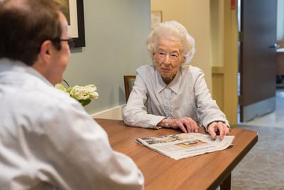 Resident and staff member engaged at a table