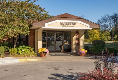 Entrance of the Riverbend facility with landscaped flowers