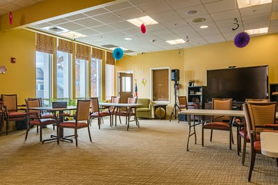 Bright common area with chairs and tables arranged for activities