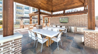 Outdoor dining space with large table and grill area